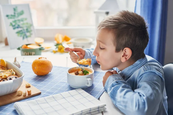 Okul için yemek tarifleri, çocuk kabak kremalı çorba yiyor.
