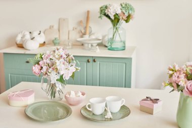 Tablo yemekleri ve bir buket çiçek vazoda Provence tarzında parlak mutfak