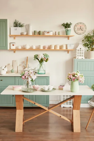 Tablo yemekleri ve bir buket çiçek vazoda Provence tarzında parlak mutfak