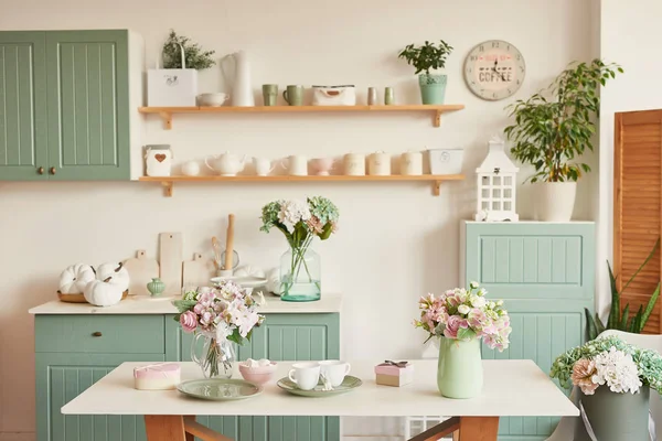 Interior light kitchen with christmas decor and tree. Turquoise-colored  kitchen in classic style. Christmas in the kitchen. Bright kitchen in mint  and white shades with Christmas. Stock Photo by ©yarovoy_aleksandr 319116004