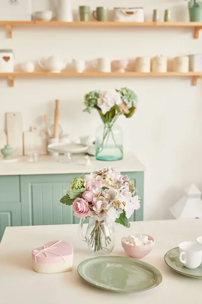 bright kitchen in the style of Provence, on the table dishes and a bouquet of flowers in a vase