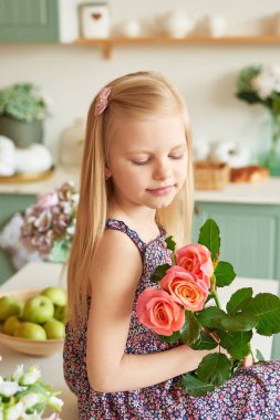 bir buket çiçek mutfakta masada oturan kızla