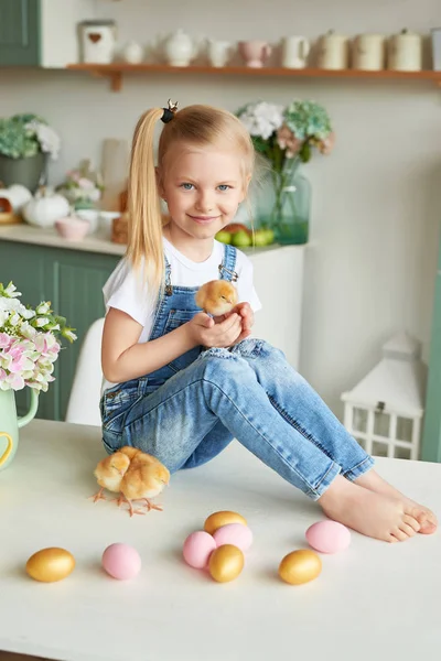 blonde girl with easter chickens in the Provence style kitchen