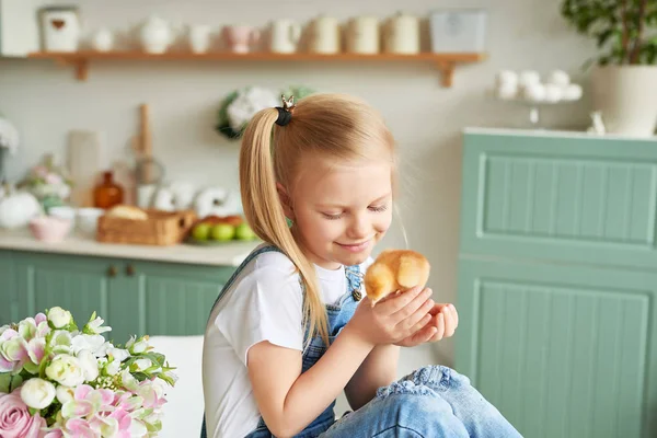 blonde girl with easter chickens in the Provence style kitchen