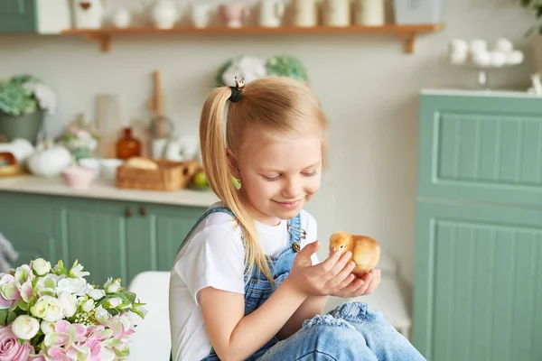 blonde girl with easter chickens in the Provence style kitchen