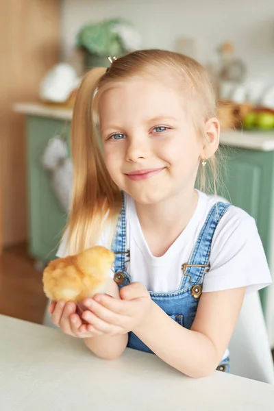 blonde girl with easter chickens in the Provence style kitchen