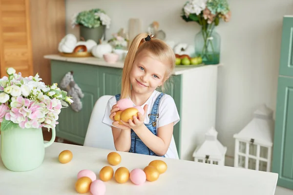 blonde girl with easter eggs in a Provence style kitchen