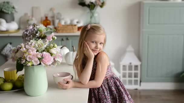 プロヴァンスのスタイルで明るいキッチンにカップを持つブロンドの女の子 — ストック動画
