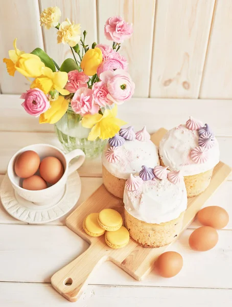 테이블에 부활절 케이크 마카롱 계란과 배경에 가까운 꽃병에 꽃다발 — 스톡 사진