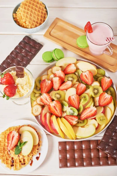 Chocolate Bars Fruit Sliced Strawberries Apples Bananas Kiwi Wooden White — Stock Photo, Image