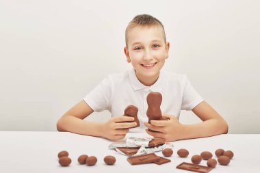 beyaz bir arka plan üzerinde Paskalya için çikolata bunnies ve yumurta ile çocuk
