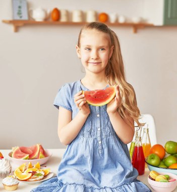 The girl eats fruit pineapple, watermelon, apples and drinks drinks from chia. Healthy food in the children's menu