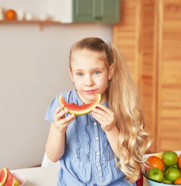 The girl eats fruit pineapple, watermelon, apples and drinks drinks from chia. Healthy food in the children's menu