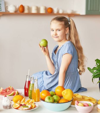 The girl eats fruit pineapple, watermelon, apples and drinks drinks from chia. Healthy food in the children's menu
