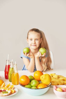 The girl eats fruit pineapple, watermelon, apples and drinks drinks from chia. Healthy food in the children's menu