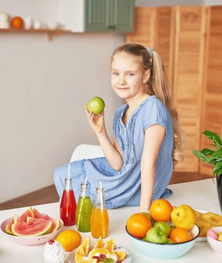 The girl eats fruit pineapple, watermelon, apples and drinks drinks from chia. Healthy food in the children's menu