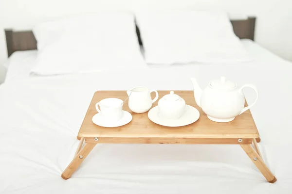 breakfast in the room on the table is on a white bed