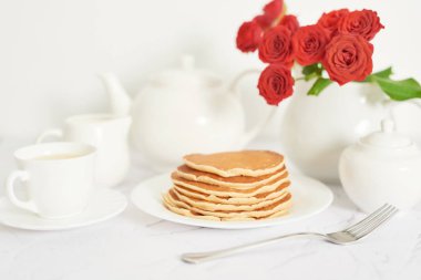 4 Temmuz 'da bağımsızlık günü, masada tabak ve kırmızı güller yanında Amerikan krep.