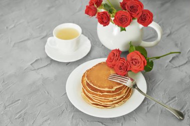 4 Temmuz 'da bağımsızlık günü, masada tabak ve kırmızı güller yanında Amerikan krep.