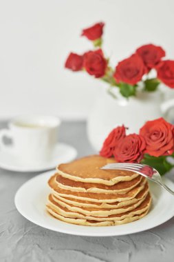 4 Temmuz 'da bağımsızlık günü, masada tabak ve kırmızı güller yanında Amerikan krep.