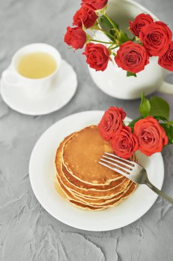 4 Temmuz 'da bağımsızlık günü, masada tabak ve kırmızı güller yanında Amerikan krep.