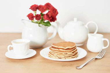 4 Temmuz 'da bağımsızlık günü, masada tabak ve kırmızı güller yanında Amerikan krep.