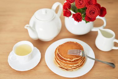 4 Temmuz 'da bağımsızlık günü, masada tabak ve kırmızı güller yanında Amerikan krep.