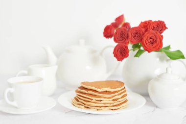 4 Temmuz 'da bağımsızlık günü, masada tabak ve kırmızı güller yanında Amerikan krep.