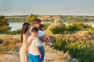 gün batımında yaz aylarında gölün yakınında tatile çocuk oğlu ve kızı ile aile