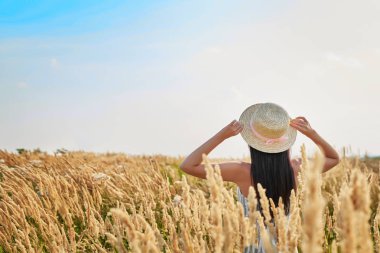 Yaz aylarında bir buğday alanında bir şapkalı kız