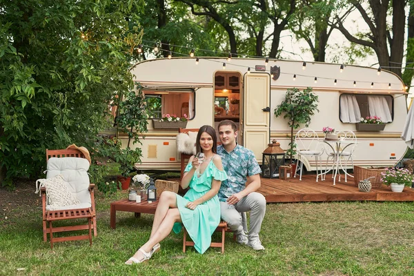 stock image young couple relaxing on a picnic in the summer near the trailer on wheels