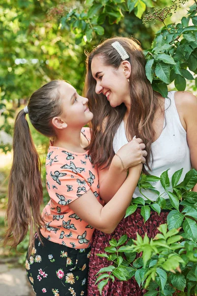 family mom and daughter in the park in the summer at sunset