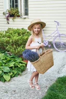 Yaz aylarında bahçede bir sepet Lavanta bir şapka ile bebek kız