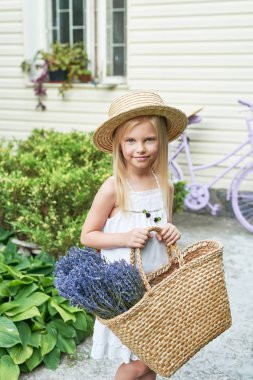 Yaz aylarında bahçede bir sepet Lavanta bir şapka ile bebek kız