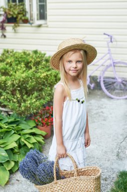 Yaz aylarında bahçede bir sepet Lavanta bir şapka ile bebek kız