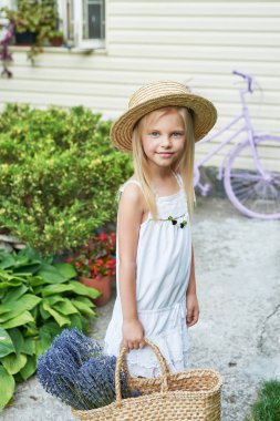 Yaz aylarında bahçede bir sepet Lavanta bir şapka ile bebek kız