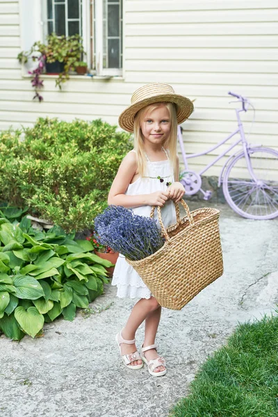 Yaz aylarında bahçede bir sepet Lavanta bir şapka ile bebek kız