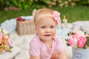 Çocuk Günü, parkta bir çocuk kız bir yaz pikniğinde makaronlarla bir sepet içinde oturuyor