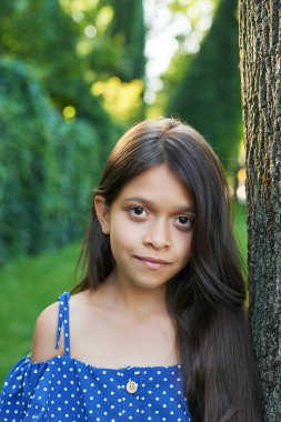 gün batımında bir yaz parkında bir ağacın yanında genç kız