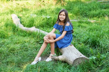 gün batımında bir yaz parkında bir ağacın yanında genç kız