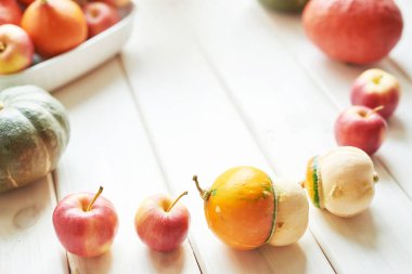 şükran veya cadılar bayramı için beyaz ahşap arka plan üzerinde elma ile kabak