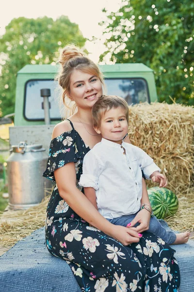 mom and son on a pickup truck with watermelons, harvesting