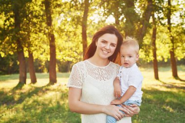 anne ve oğlu anneler gününde gün batımında parkta yürümek