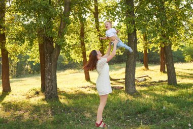 anne ve oğlu anneler gününde gün batımında parkta yürümek