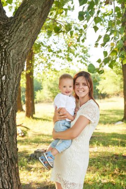 anne ve oğlu anneler gününde gün batımında parkta yürümek