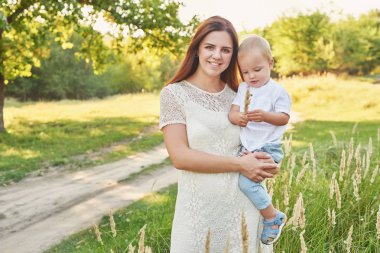anne ve oğlu anneler gününde gün batımında parkta yürümek