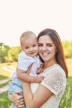 anne ve oğlu anneler gününde gün batımında parkta yürümek
