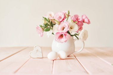 pembe ahşap arka plan üzerinde paskalya için yumurta ile çiçekler