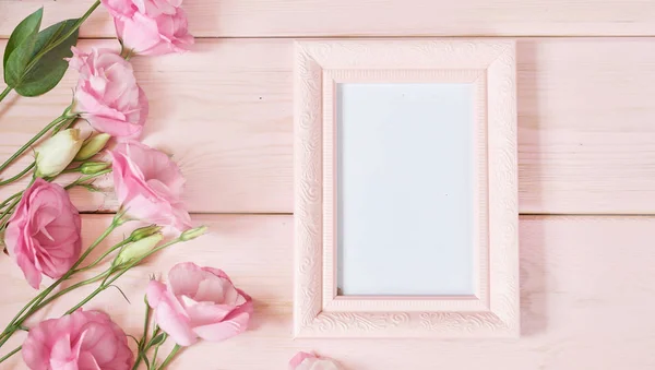 photo frame and flowers on a pink background