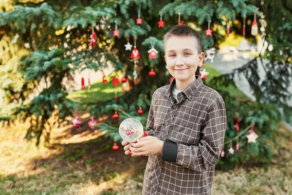 Niño Con Una Bola Nieve Cristal Cerca Del Árbol Navidad — Foto de Stock